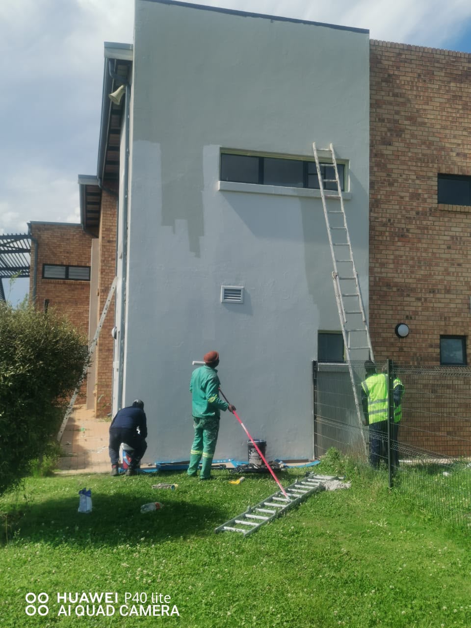 Team painting an exterior building wall